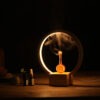 Luna Waterless Nebuliser With Glowing Led Ringlight And Amber Glass Reservoir On A Wooden Table.