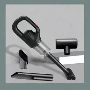 Portable cordless vacuum cleaner in crystal green finish being used to clean car dashboard
