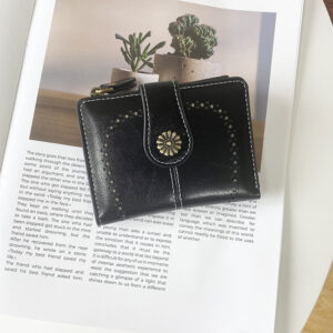 Front view of closed black vintage PU leather womens short wallet cut out design with decorative clasp on white background